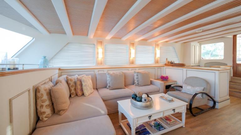 Cozy large sofas with cushions. You can see an armchair and a book table